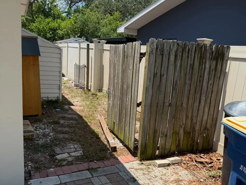 Weathered wood fence and gate in need of repair in Tampa, FL