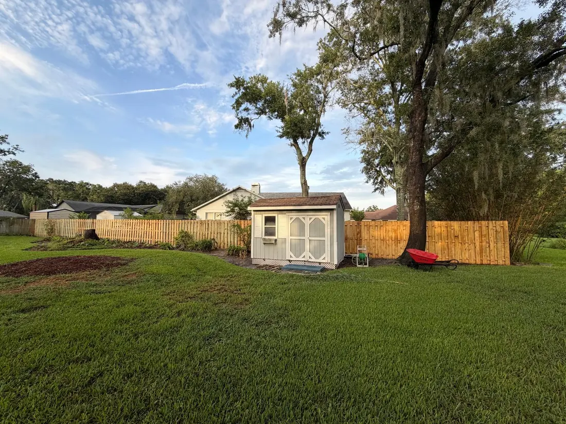 Natural wood picket fence around a backyard shed