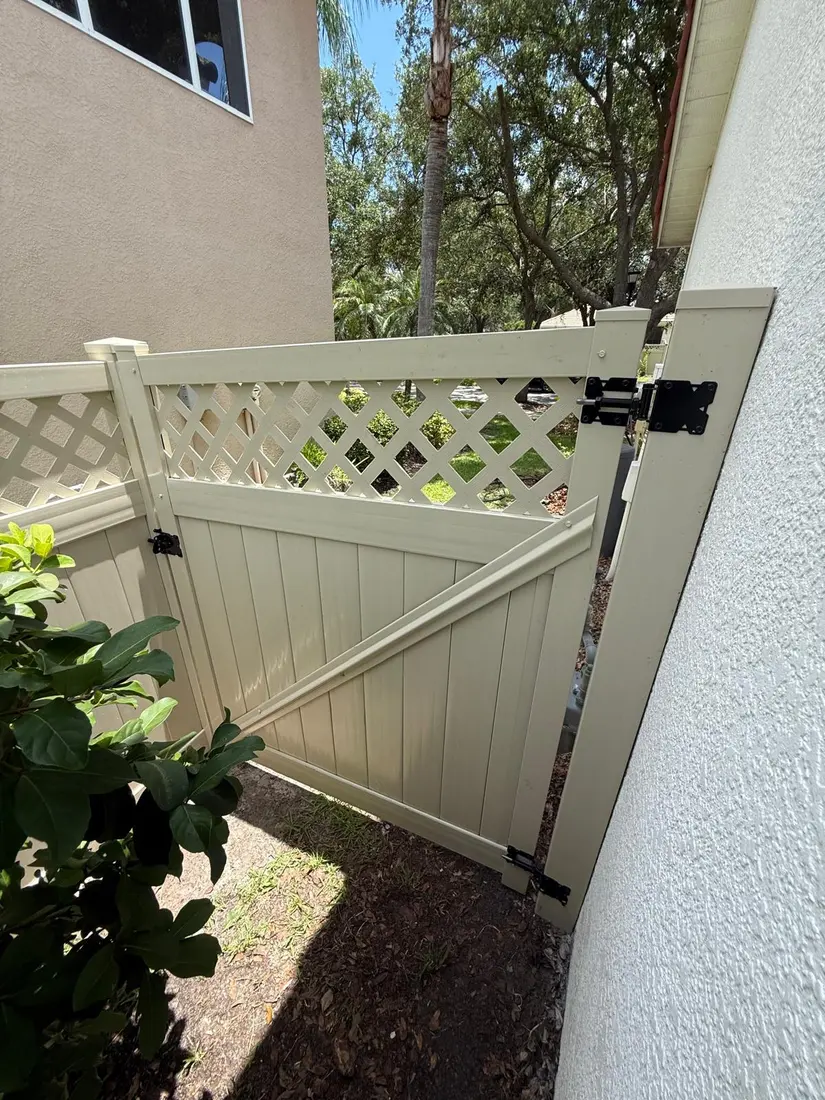 Vinyl gate with lattice top beside a Florida home