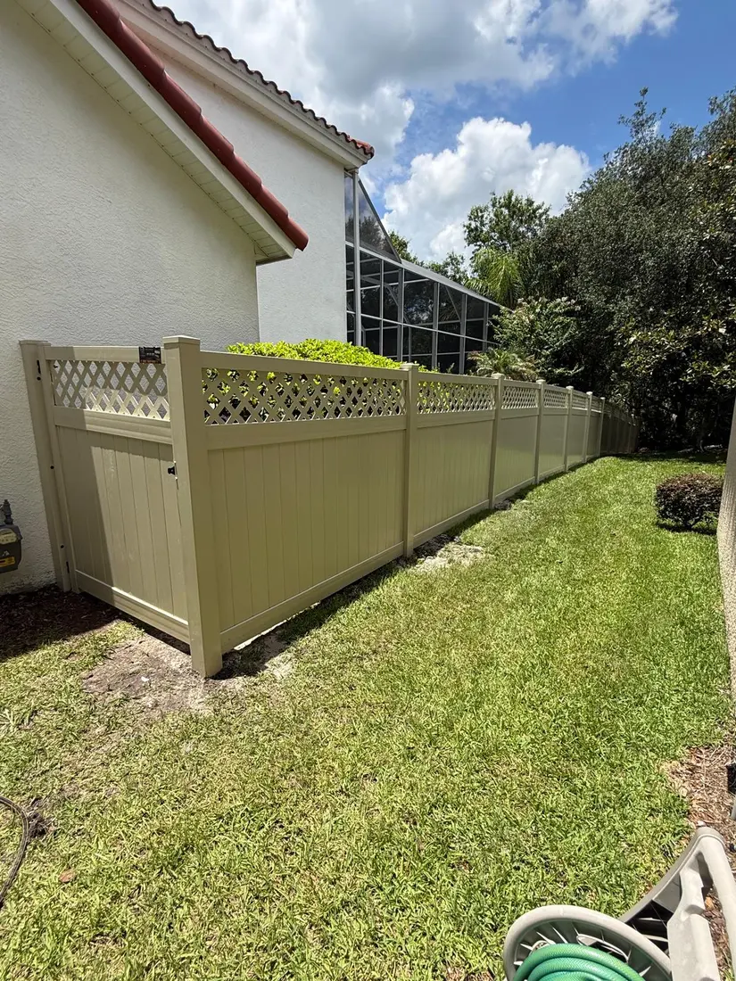 Tan vinyl fence with lattice top beside a screened pool