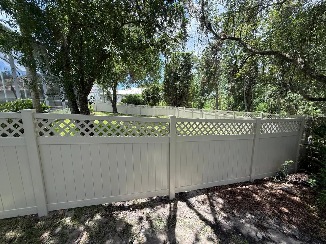 White vinyl fence with lattice top beside a screened pool