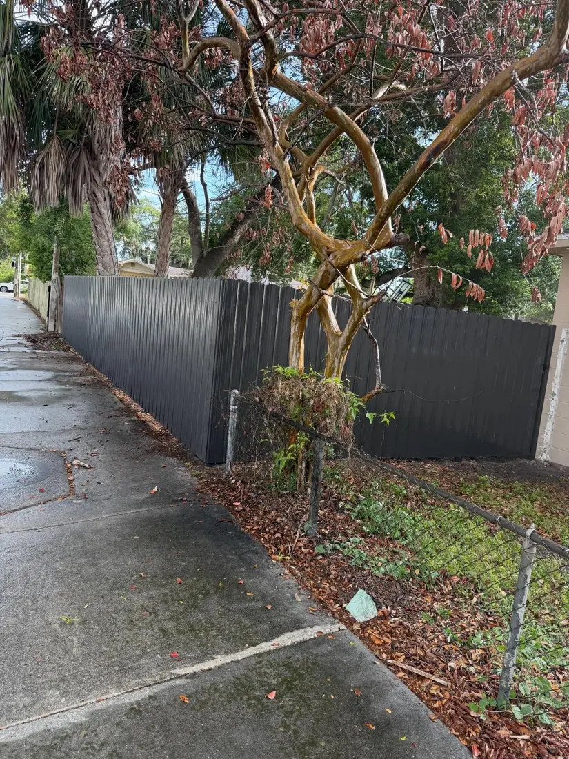 Dark privacy fence along a sidewalk