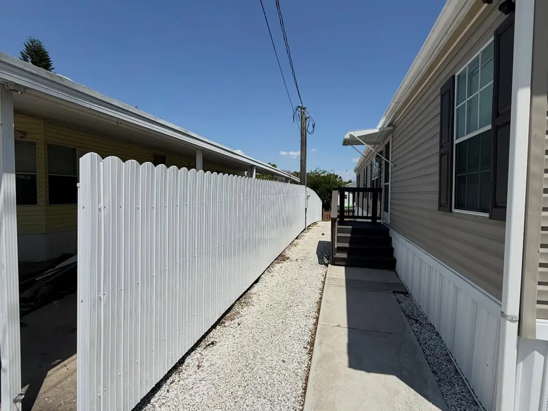 White vinyl fence along a side-yard walkway