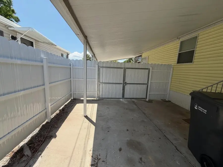 Fence company Fort Myers, FL β white vinyl gate installed under a carport